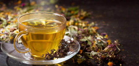 Glass cup of herbal tea with dried flowers